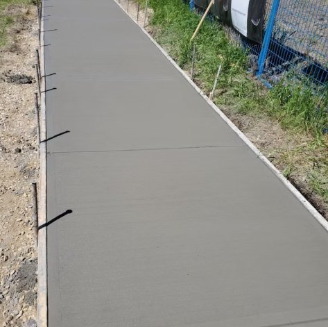 Long commercial sidewalk next to a construction fence