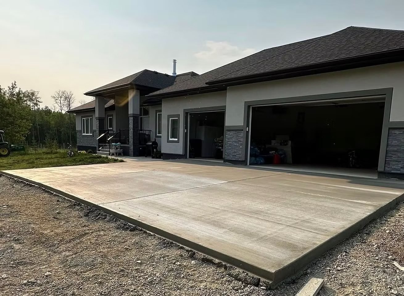 New concrete garage pad in front of a three-car garage