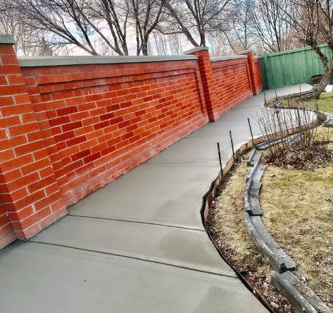 Curved walkway along a red brick wall